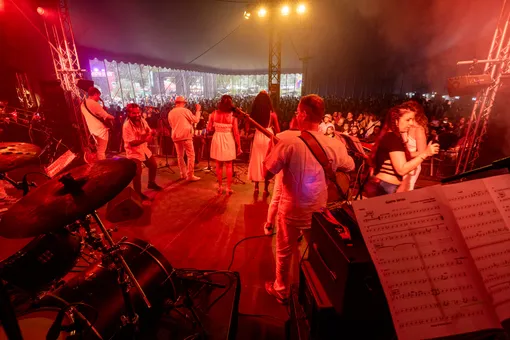 La scène du LakeLive vue de la batterie — l’orchestre en blanc face au public massé sous le grand chapiteau