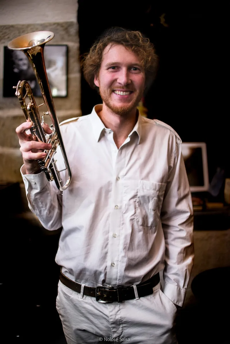 Trompette argentée à la main d'un musicien de Nolosé, portrait studio